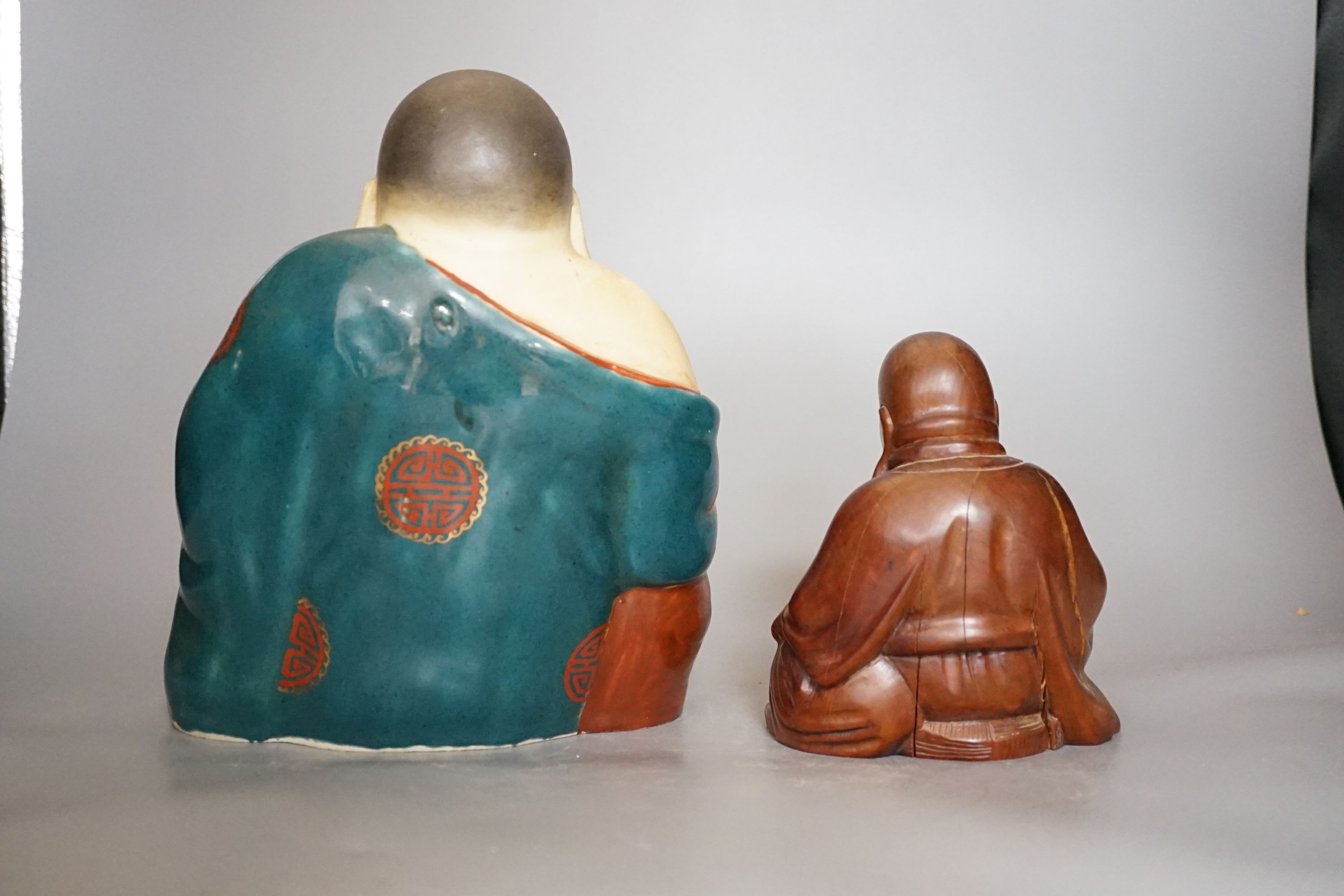 A Chinese enamelled porcelain figure of Budai and a similar carved wood figure (2)